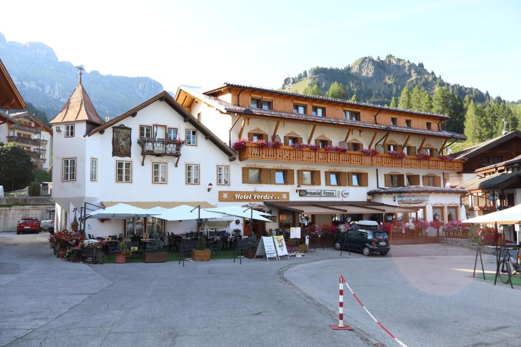 a large building with a market in front of it at Hotel Pordoi - Fam Furgler in Arabba
