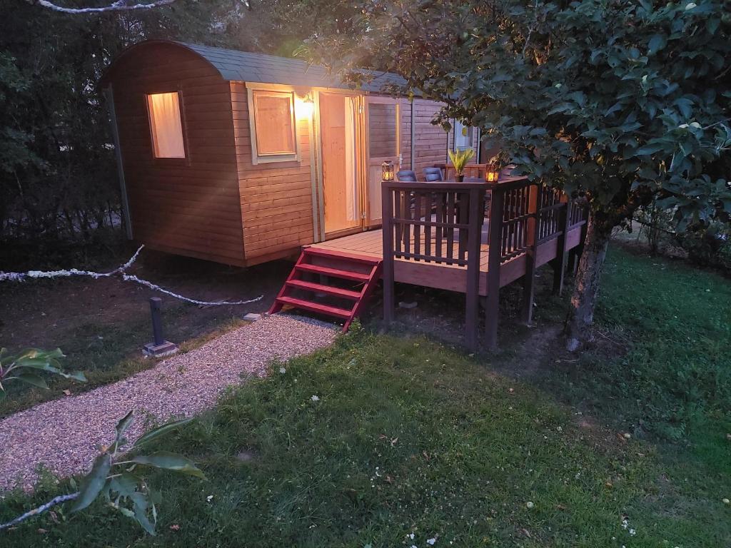 a small cabin with a table in the yard at La roulotte enchantée in Le Boissenet