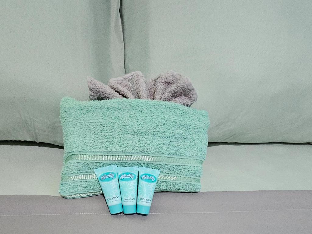 a basket of towels and two pairs of slippers at Hidden Bungalow in Roseau