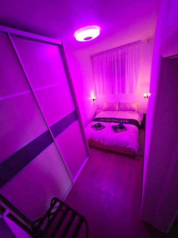 a purple room with a bed and a mirror at Apartman Ogulin "Klek Escape" in Sveti Petar