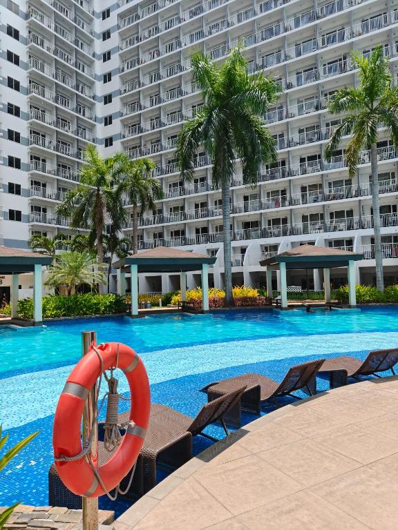 a large swimming pool with a large building in the background at Shell Residences MOA - Josh staycation in Manila