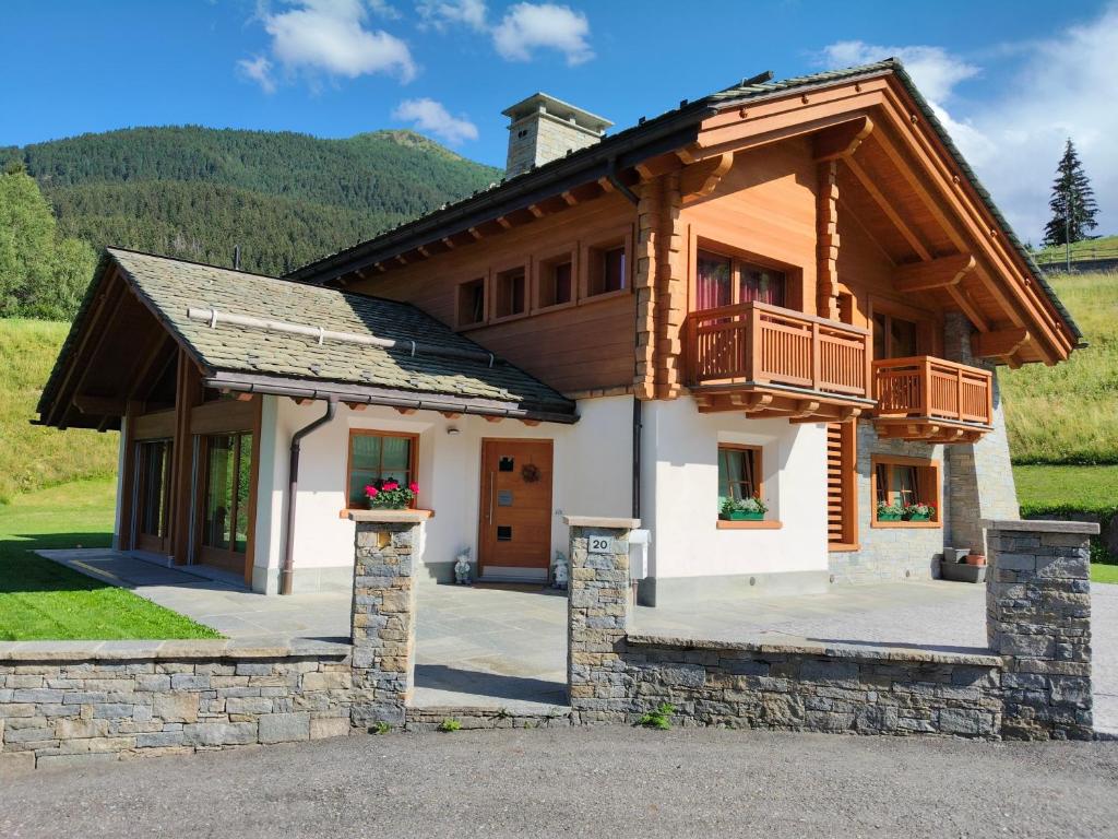 a house with a porch and a balcony at Chalet Taulei tra Bormio e Livigno in Valdidentro