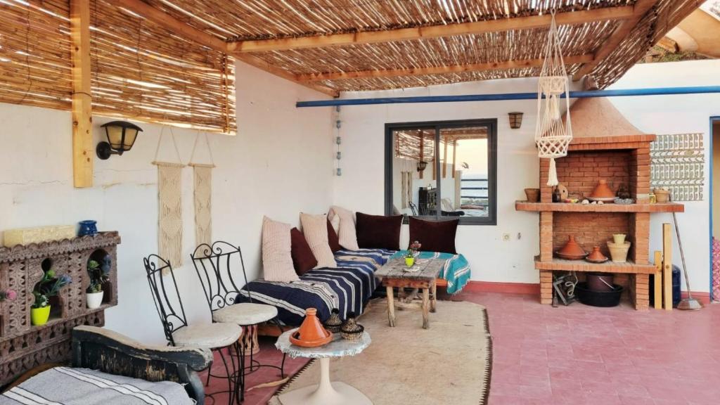 a living room with a couch and a fireplace at Gypsy Surf Maroc Hostel in Tamraght Ouzdar