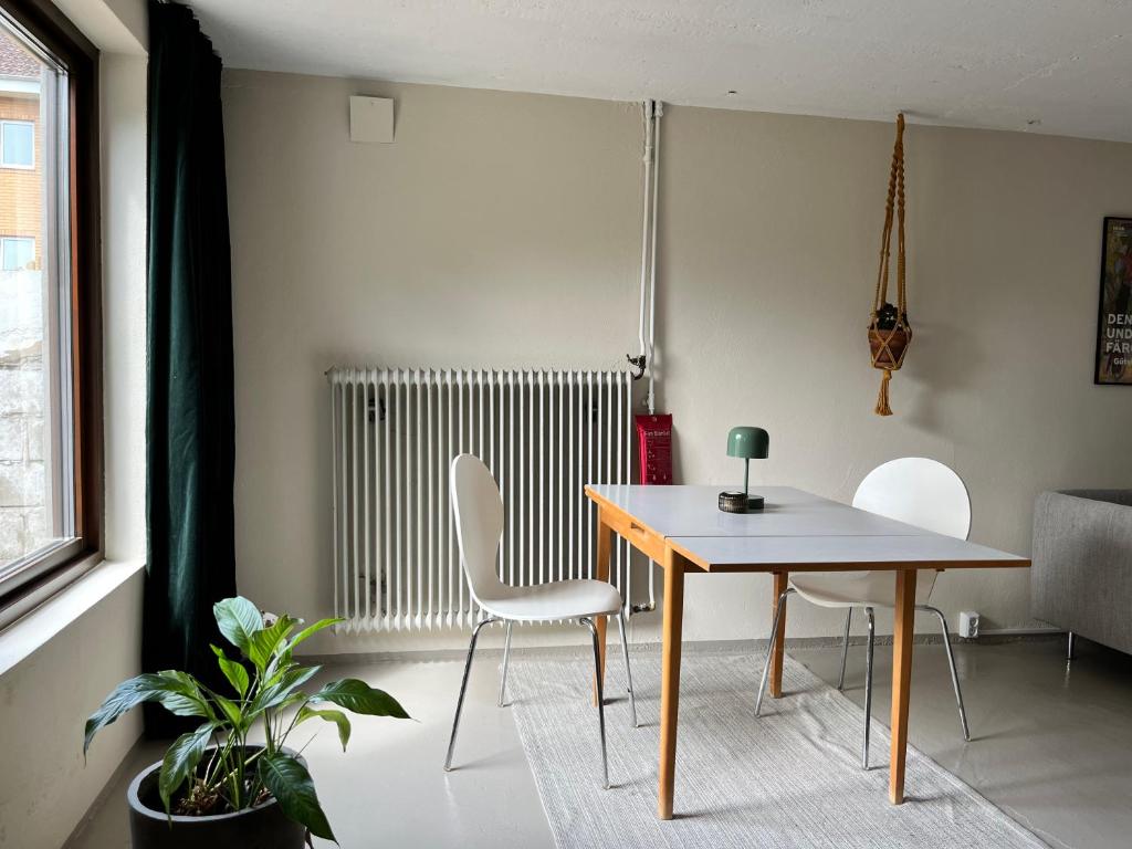 a dining room with a table and chairs and a radiator at Sommarboende i centrala Varberg in Varberg