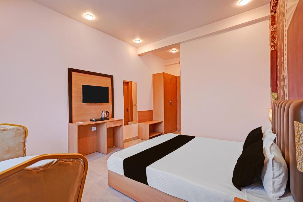 a hotel room with a bed and a tv at Hotel O Gomti Garden And Resort in Jhānsi