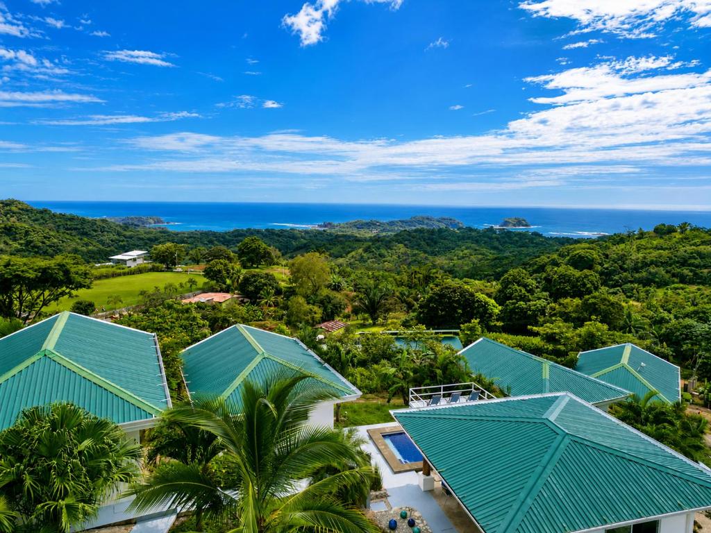 an aerial view of a resort with blue roofs at Lodge Las Estrellas de Samara - Ocean View in Sámara