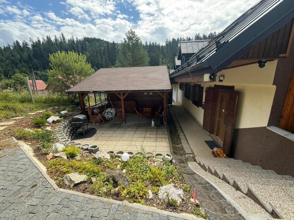 a building with a table and a pavilion in a garden at Zejmarka in Mlynky