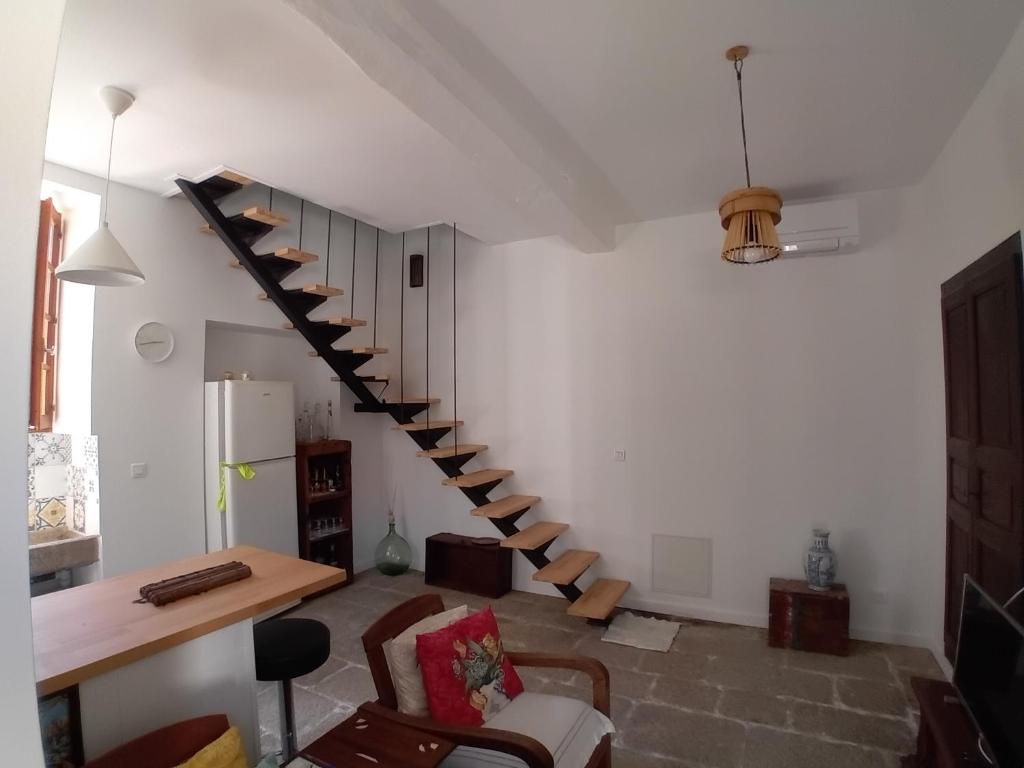 a living room with a spiral staircase in a house at Casetta - Appartement dans maisonnette rustique in Cognocoli-Monticchi