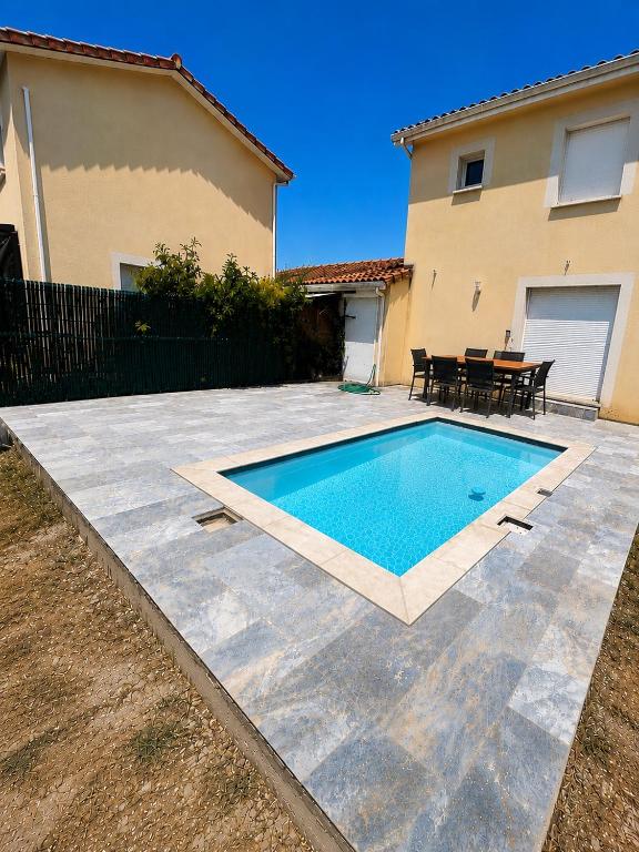 a swimming pool in a yard next to a house at La maison ensoleillée in Bérat