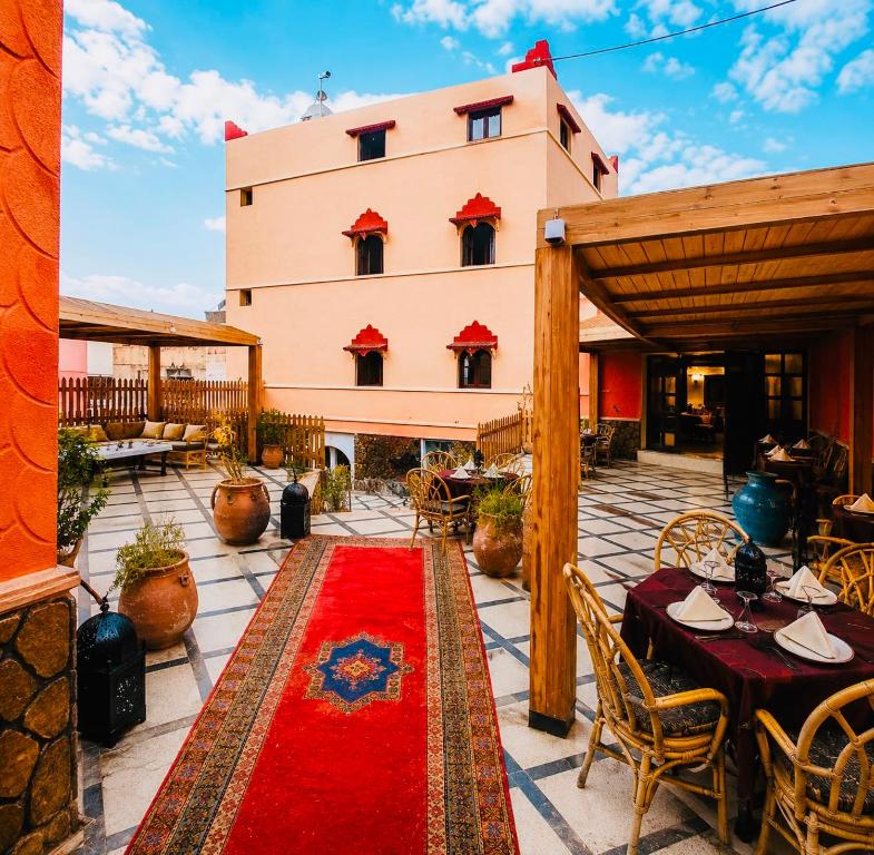 a patio with a red rug in front of a building at Hotel la renaissance tata in Tatta