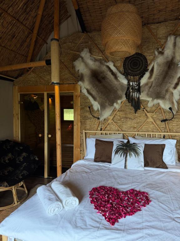 a bedroom with a bed with a heart made out of flowers at Lakajų Resort in Molėtai
