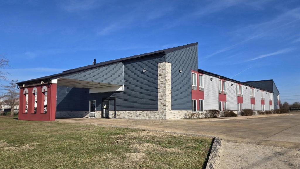 a large building with red doors and a garage at Super 8 by Wyndham O'Fallon MO/St. Louis Area in O'Fallon