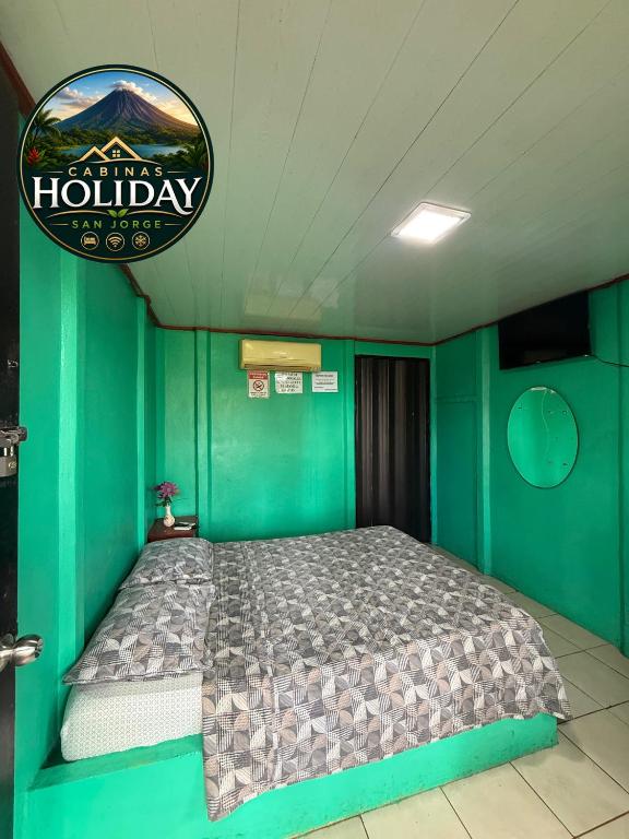 a bedroom with a bed in a green wall at Holiday San Jorge in Fortuna