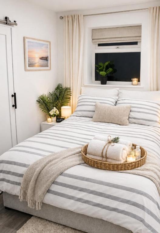 a bedroom with a large white bed with a basket on it at UNLIMITED-PEACE PRIVATE STUDIO APARTMENTs in Weston-super-Mare