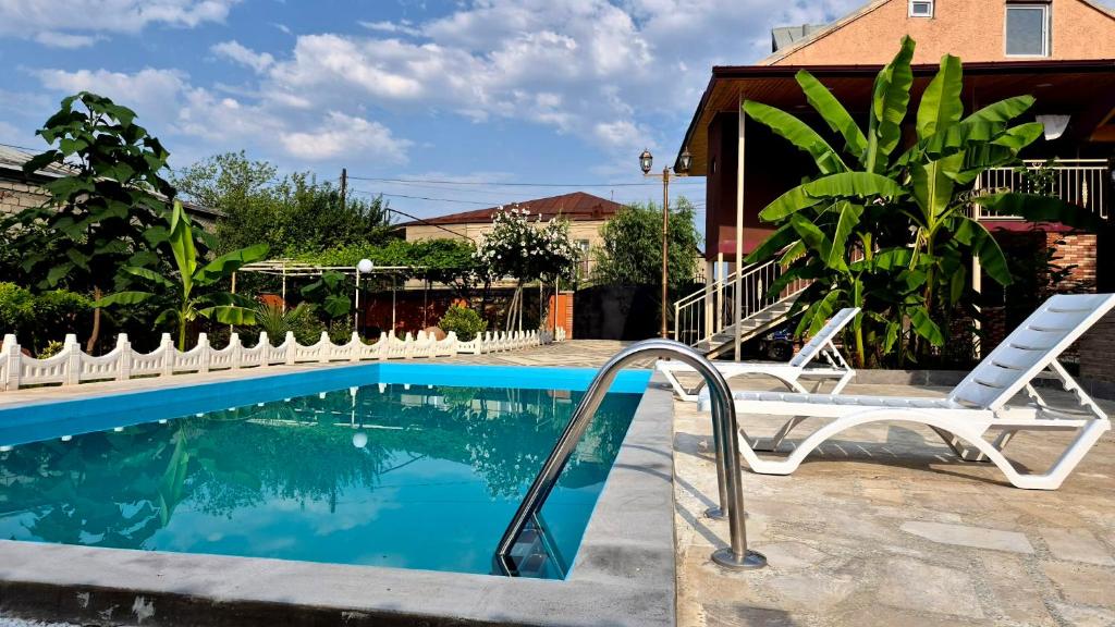 a swimming pool with a white chair at Busheti Home in Telavi