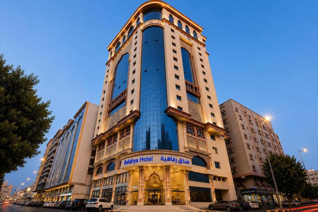 a tall building with a sign on the side of it at فندق رفاهية العزيزية in Al ‘Azīzīyah