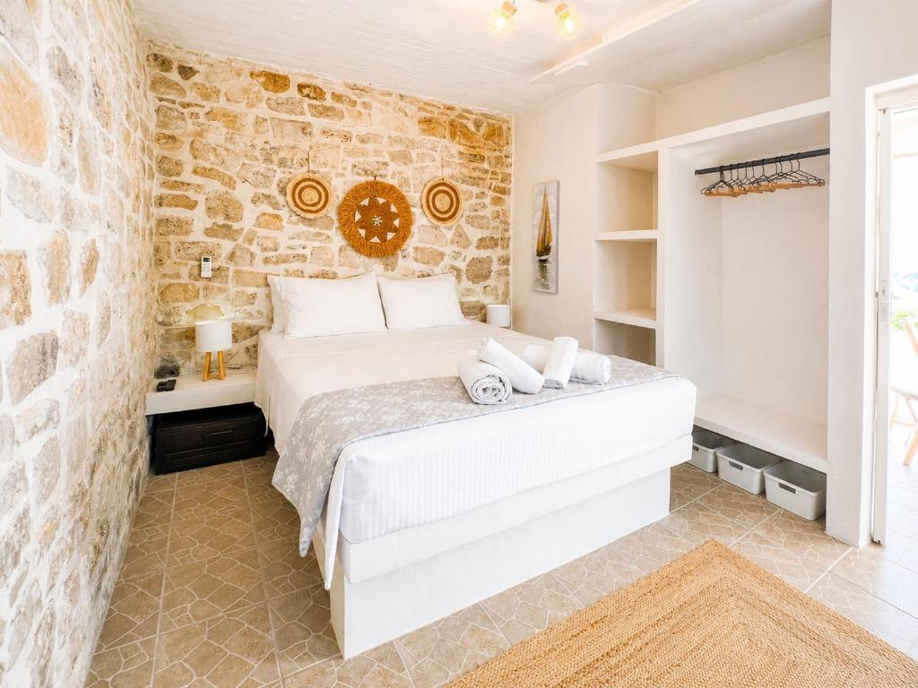 a bedroom with a bed and a stone wall at Casa Rapata in Gaios
