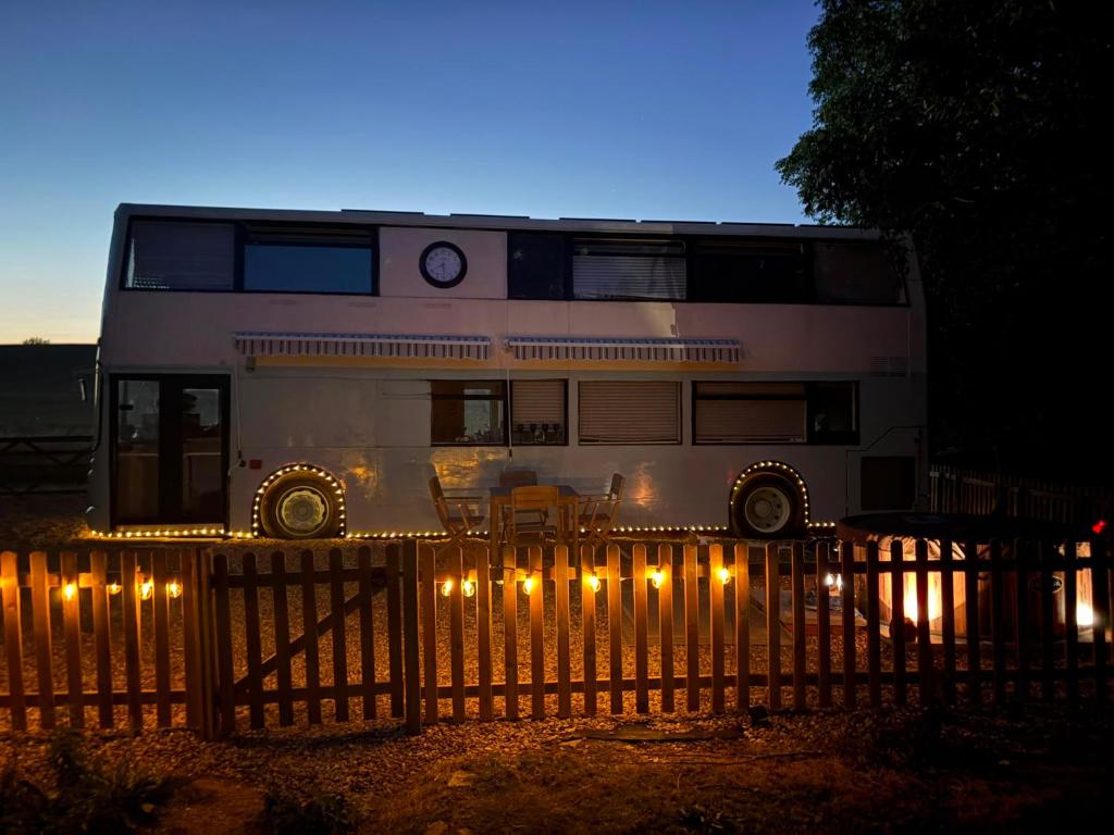 a double decker bus parked behind a fence at Debdale Bus Retreat in Little Dalby