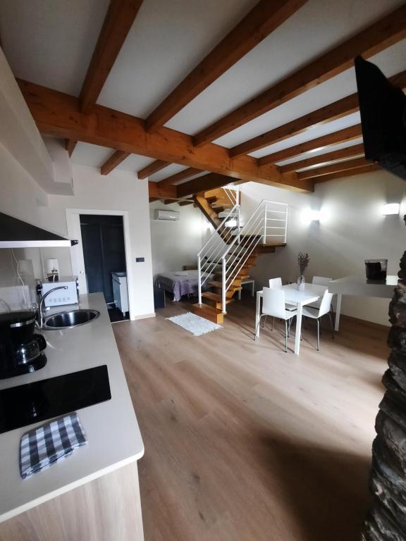 a kitchen and living room with wooden ceilings and a staircase at Vista Real in Mugardos