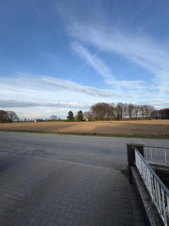 an empty road with a fence next to a field at Landglück in Ibbenbüren