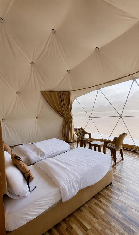 a bedroom with a bed and a table and chairs at وادي رم in Wadi Rum