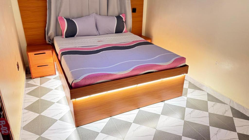 a small bed with a wooden frame in a room at Kent One Hotel in Fort Portal