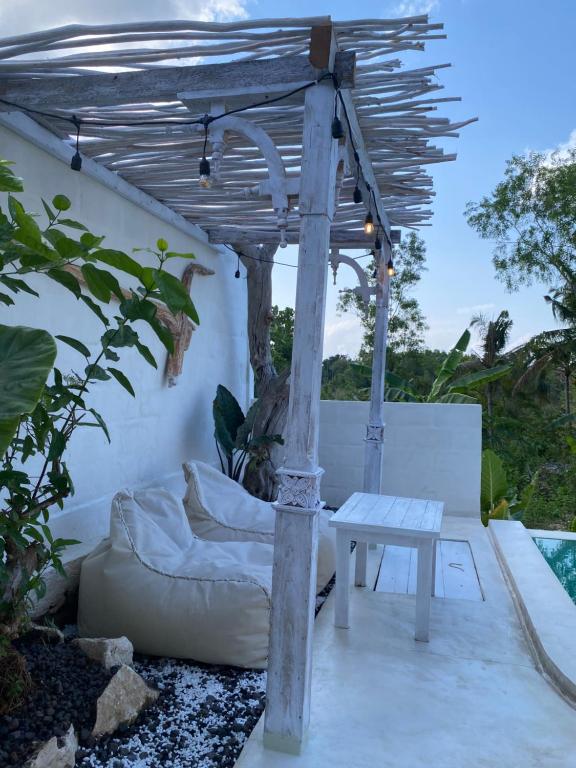 a pergola with a couch and a table at Romantic private villas Buvillas nusa penida in Nusa Penida