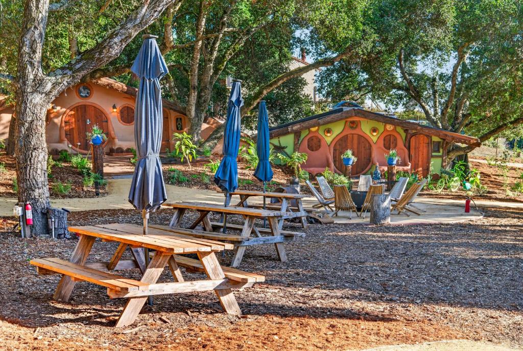 a group of picnic tables with umbrellas in a park at Hobbit Hideout in Watsonville