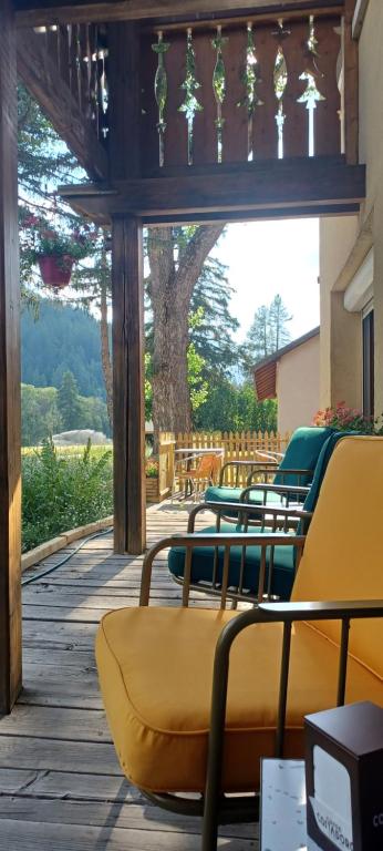 a group of chairs sitting on a wooden deck at Abries Hôtel in Abriès