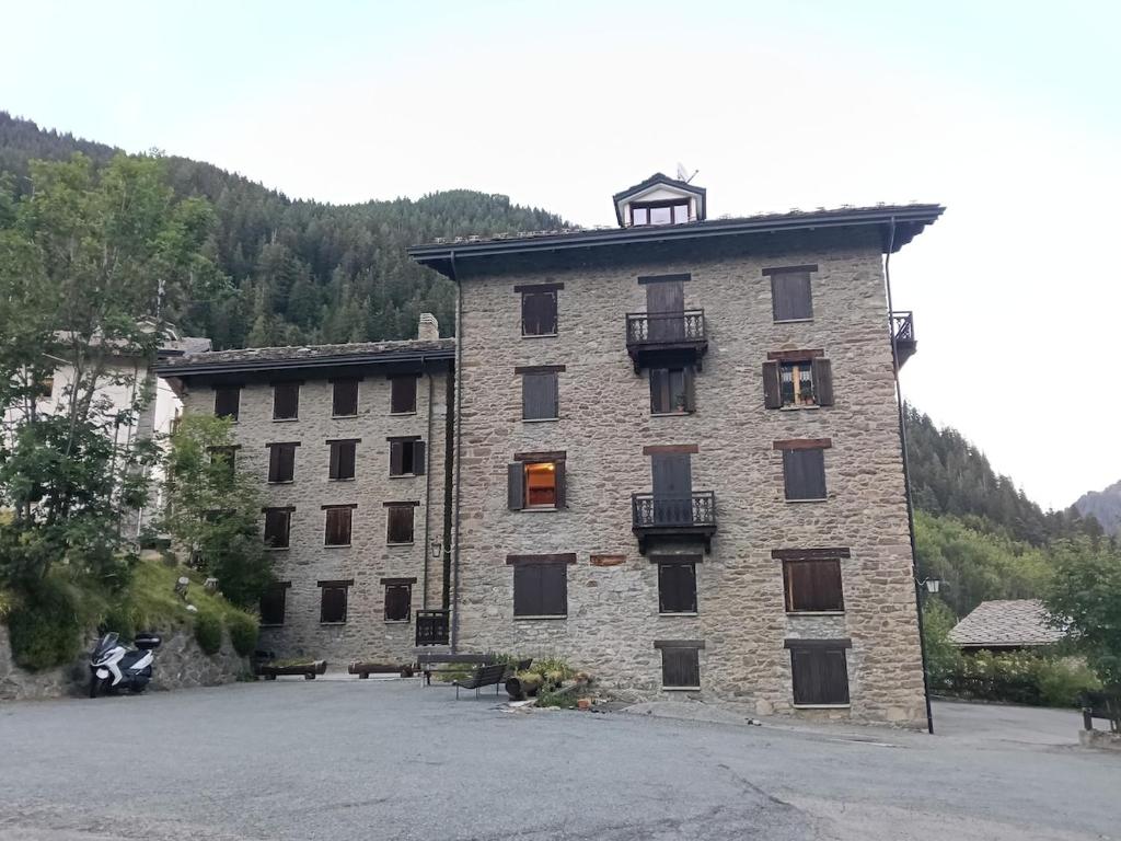 a large brick building with windows and a balcony at Il gallo alpino a Champorcher in Champorcher