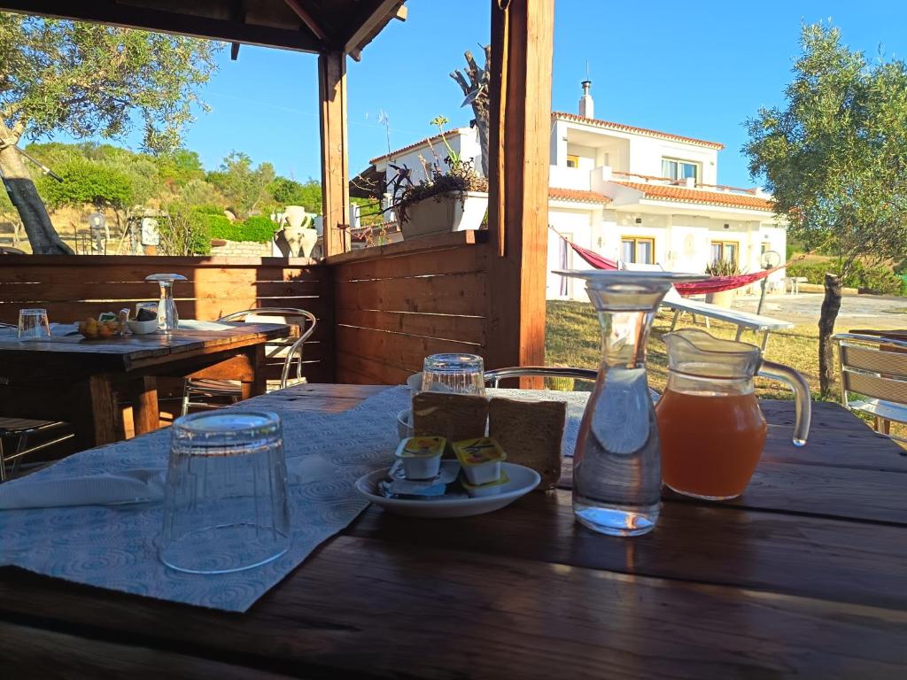 a table with a bottle of juice and glasses on it at Villa Rosa in Surrau in Arzachena
