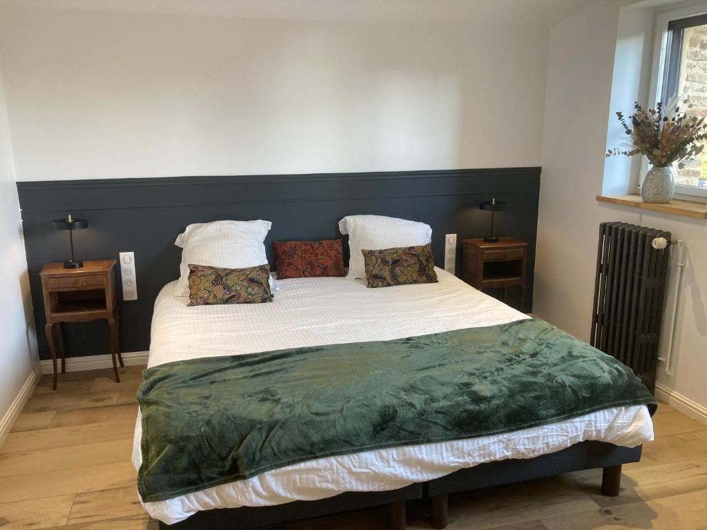 a bedroom with a large bed with white sheets and pillows at Le Tilleul in Pluvigner