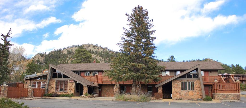 uma casa grande com uma árvore em frente em The Maxwell Inn em Estes Park