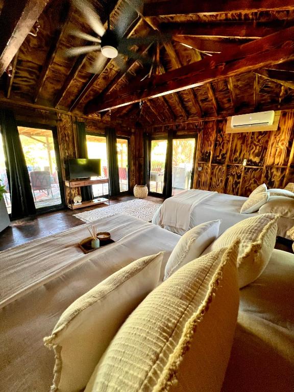 a bedroom with two beds in a room with windows at JAWS Retreat Bungalow in Haleiwa