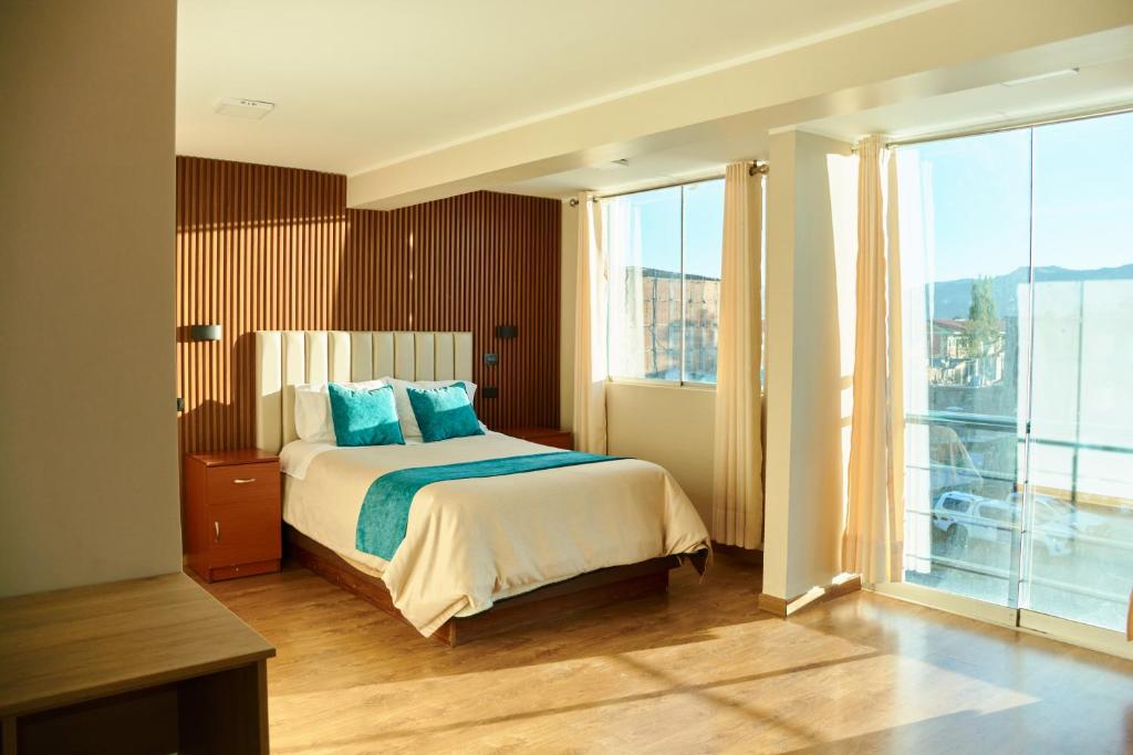 a hotel room with a bed and a large window at QAIPU HOTEL in Puquio