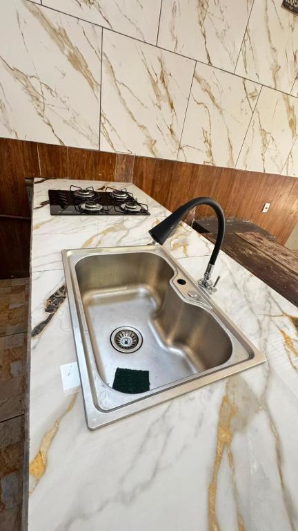 a kitchen counter with a sink and a stove at Top festas in Campinas