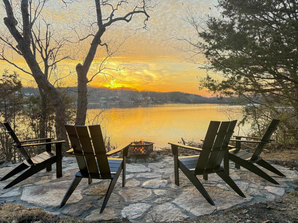 three chairs and a table with a view of a lake at Gatliff Getaway in Warsaw