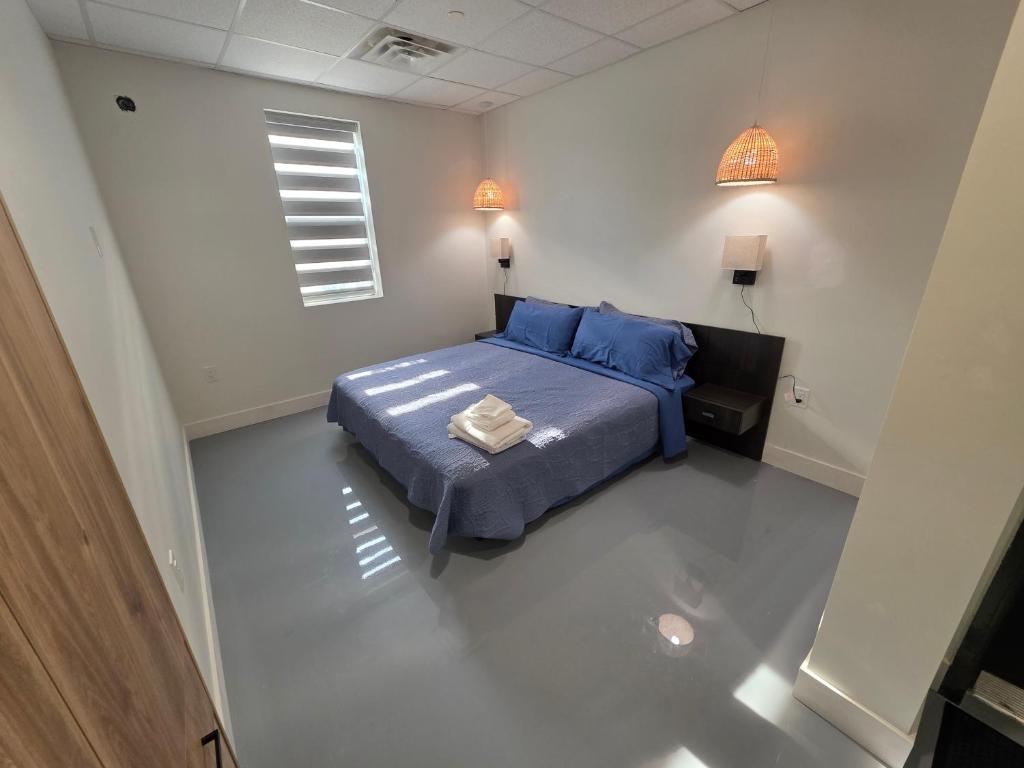 a bedroom with a blue bed and a window at Lakeview Main Floor Suite 104 in Peachland