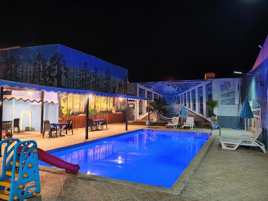 a swimming pool with a slide in front of a building at Villa Drayd in Ait Melloul