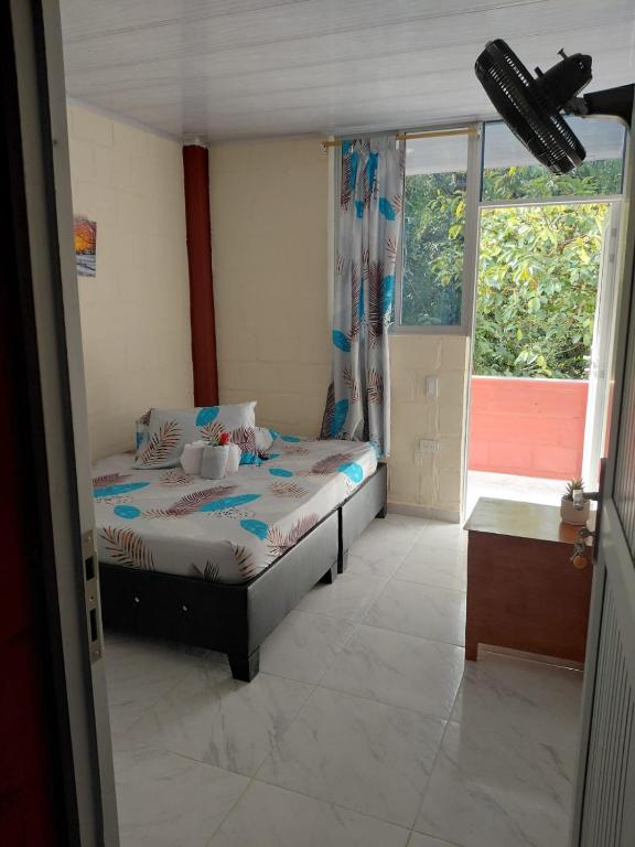 a small bedroom with a bed and a window at Hotel GinaMar Ladrilleros in Buenaventura