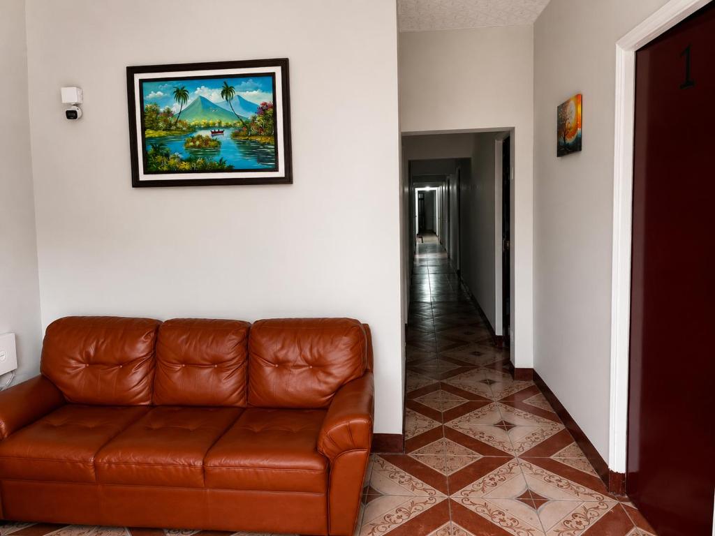 a brown leather couch in a hallway with a picture on the wall at EL Viajero ll in Estelí