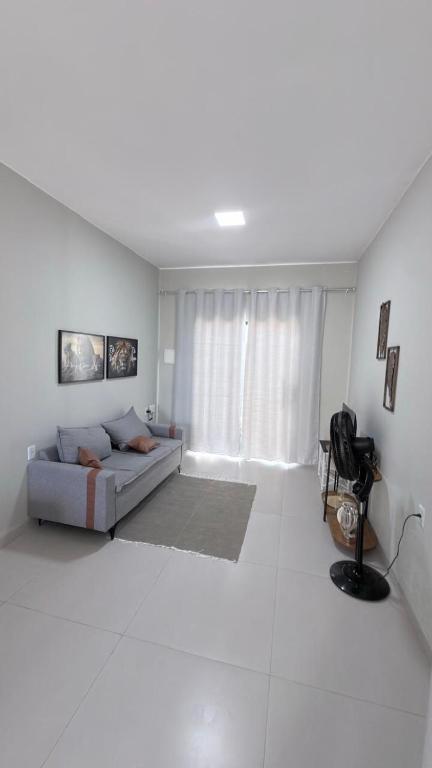 a white living room with a couch and a window at Lar doce lar in Paragominas