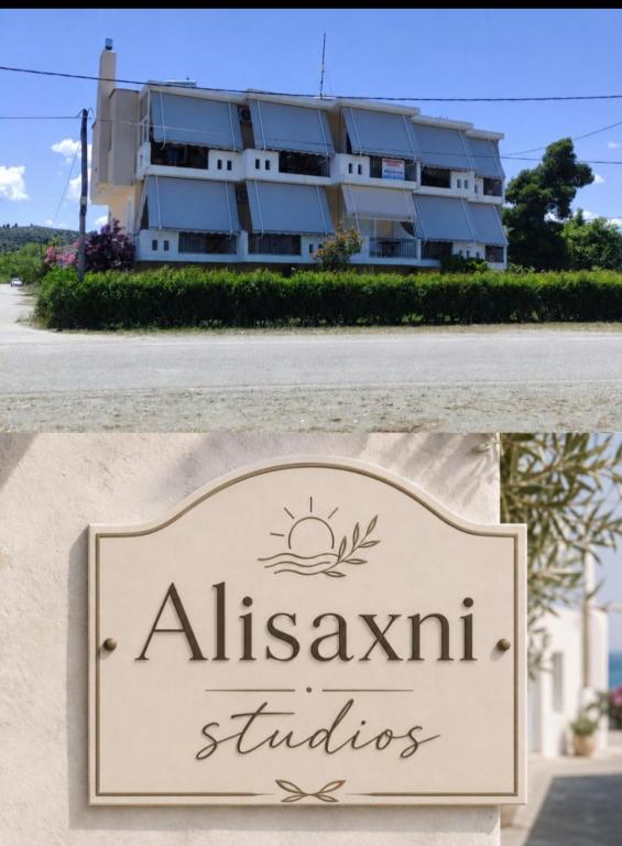 a sign for a hotel with a building in the background at Alisaxni Studios in Pefki