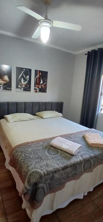 a bedroom with a large bed with a ceiling at Quarto Casal Cinza in Artur Nogueira