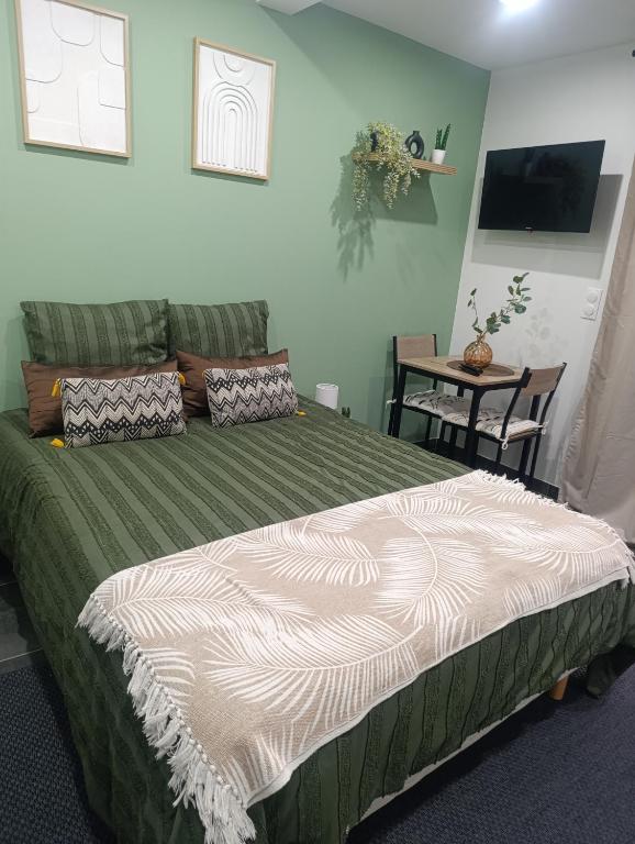 a bedroom with a bed and a table with a chair at Studio cosy Boulazac in Boulazac