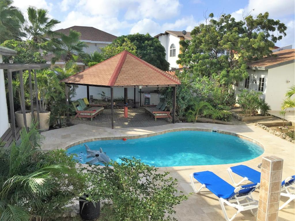 鷹海灘的住宿－鸚鵡別墅酒店，一个带两把椅子的游泳池和一个凉亭