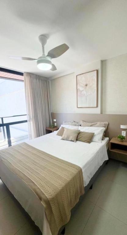 a bedroom with a large bed with a ceiling fan at Namas 406 Niterói - perto da UFF, Barcas e Praias in Niterói