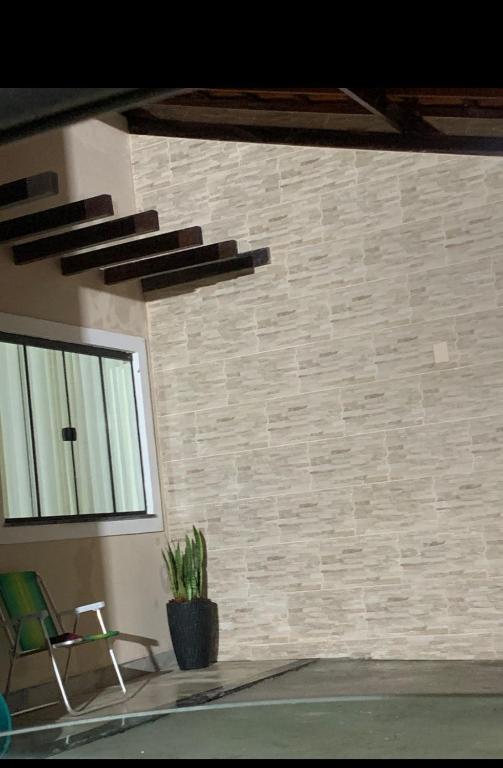 a brick wall with a window and a potted plant at Casa Aconchegante in Barbacena