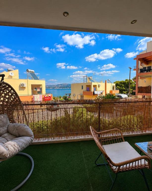 a balcony with chairs and a view of the water at Terra boho apartment in Ambelákia