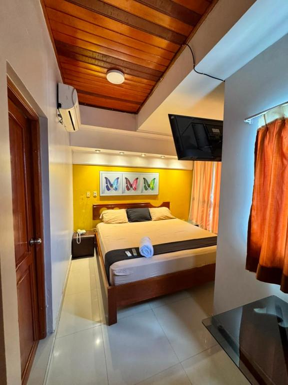 a bedroom with a bed and a flat screen tv at Hotel Confort Amazónico in Iquitos